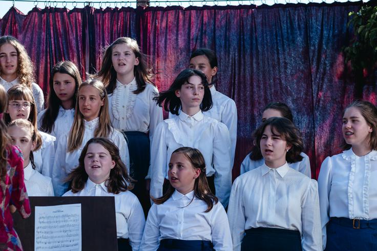 Ida, ki je pela tako grdo, da so še mrtvi vstali od mrtvih in zapeli z njo, se med zborovskim nastopom zagleda v nekaj izven kadra. | Foto: Temporama