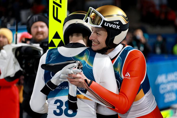 Srebrni Kacper Tomasiak, ki v svetovnem pokalu še ni stal na stopničkah posamične tekme, v objemu bronastega Gregorja Deschwandna, ki ga trenira Bine Norčič. | Foto: Reuters