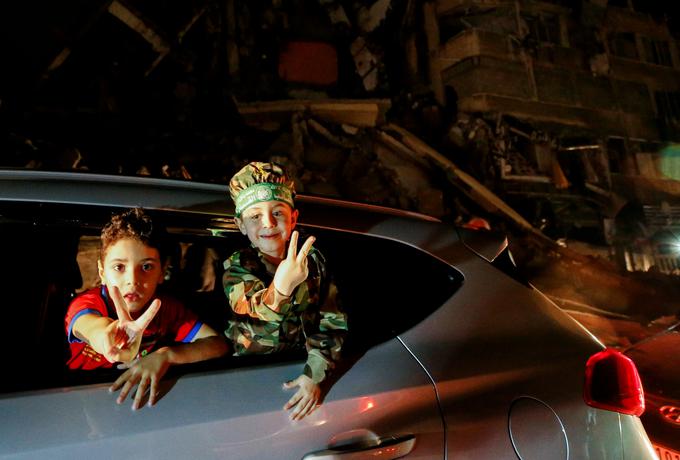 Otroka med vožnjo z znakom za mir oznanjata konec spopadov. 
 | Foto: Reuters