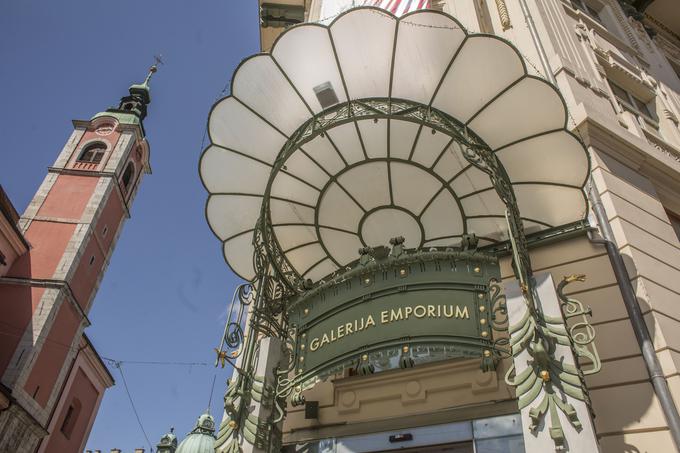 Vhod v Urbančevo hišo, ki se odpira proti osrednjemu mestnemu trgu, katerega stavba zaokrožuje, krasi pahljačast nadstrešek iz steklenih, kovinsko obrobljenih cvetnih listov. Nad njim je v vertikalno linijo postavljen še kip Merkurja, zaveznika trgovcev. Nadstrešek velja za najbolj pristnega v secesijskem slogu v Ljubljani, ki nima primere.
 | Foto: 