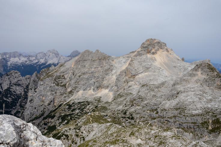 Še pred najzahtevnejšim delom vzpona se nam odpre ta pogled na Razor in Planjo  Zadaj sta Jalovec in Mangart, spodaj pa Kriški podi. | Foto: Matej Podgoršek