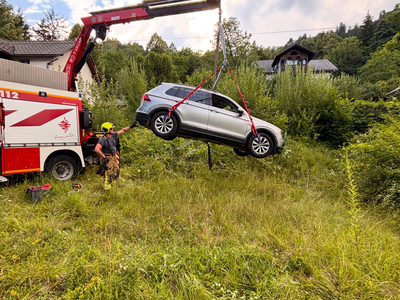 Avto zapeljal čez strmo brežino in obstal na betonskem podpornem zidu