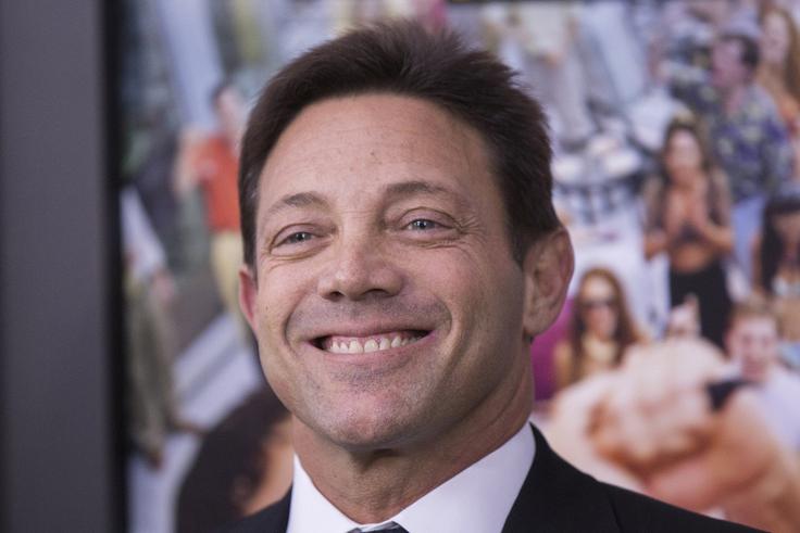 Jordan Belfort je v prvi polovici devetdesetih let prejšnjega stoletja vlagatelje prek svoje borzne hiše Stratton Oakmont s tako imenovano metodo "pump and dump" (lažno napihovanje vrednosti nečesa, da bi vlagatelji to kupili po visoki ceni) obral za več kot 200 milijonov ameriških dolarjev. Leta 1996 je bil zaradi poslovne goljufije obsojen na štiriletno zaporno kazen, a je odslužil manj kot polovico. Leta 2007 je o svoji kontroverzni poslovni poti napisal knjigo Volk z Wolf Streeta, ki jo je Hollywood leta 2013 uporabil za temelj zelo uspešnega filma z istim naslovom, v katerem je Belforta upodobil Leonardo DiCaprio.  | Foto: Reuters