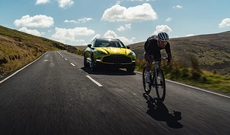 Marc Cavendish s kolesom "beži" pred aston martinom DBX. | Foto: 