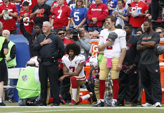 Colin Kaepernick je bil prvi igralec v zgodovini lige NFL, ki je v znak protesta proti rasizmu in policijskemu nasilju nad temnopoltimi med predvajanjem ameriške himne protestno pokleknil. | Foto: Reuters