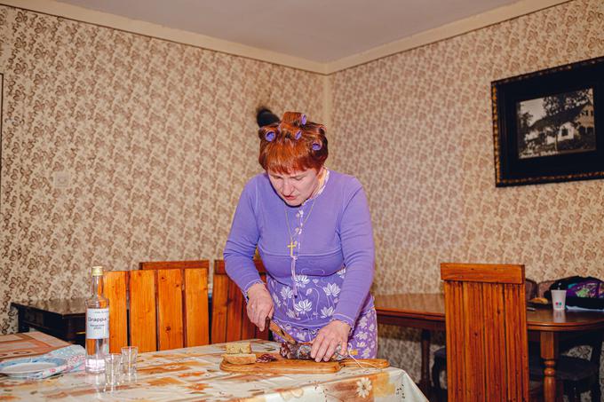 Stanka Macuh kot teta Trezika v tipično opremljeni kmečki izbi pripravlja malo domače salame za goste iz Ljubljane. | Foto: promocijsko gradivo