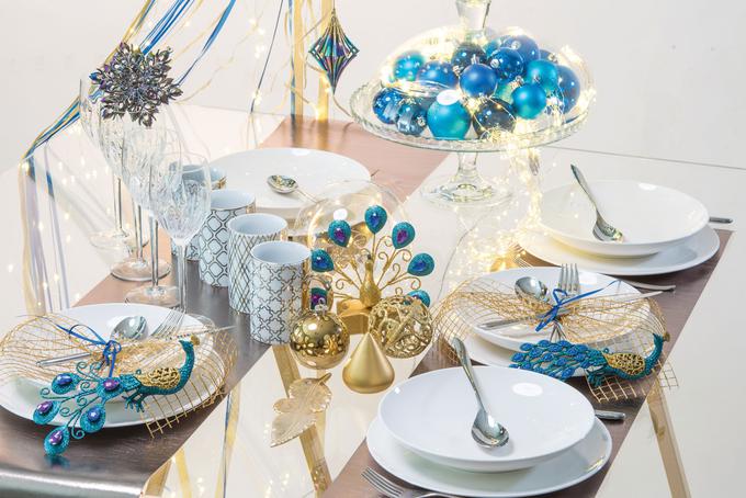 Za bolj glamurozni učinek pri zlati kombinaciji uporabite zlato-modre okraske z motivom pava ali snežink. | Foto: Arhiv Merkur