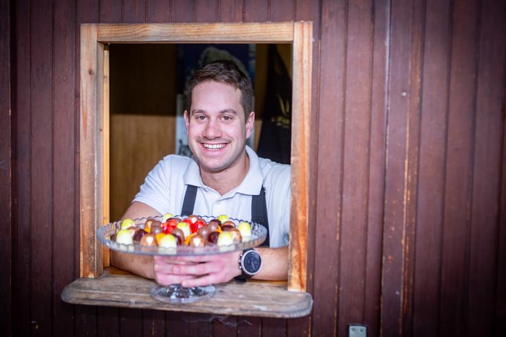 "Nedaleč od delavnice je osnovna šola in že takrat, ko je praline delal oče, so otroci trkali na vrata in spraševali po čokoladi. Vmes so jim v šoli prepovedali, da prihajajo po čokolado, zdaj pa spet radi pridejo," pove Maks Pogačnik in pojasni, da je majhno okno na vratih delavnice namenjeno otrokom, ki pridejo po čokolado.  | Foto: Gaja Hanuna