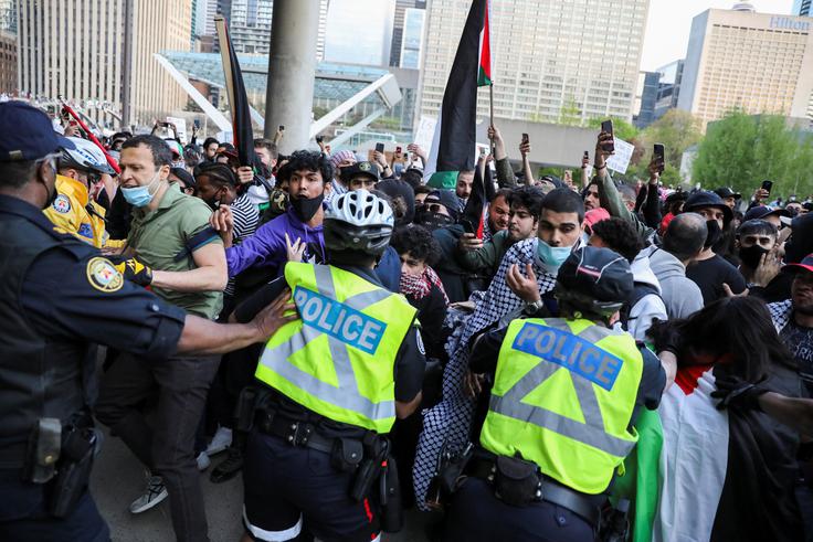 Montrealska policija, ki je proteste označila za nezakonite, je posredovala in uporabila solzivec, da bi ločila in razgnala obe skupini.  | Foto: Reuters
