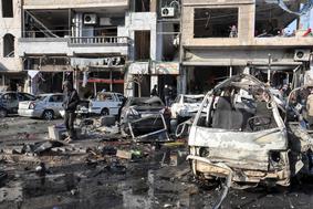 V eksplozijah avtomobilov bomb v Homsu več deset mrtvih