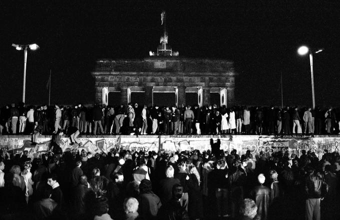 Prebivalci Zahodnega in Vzhodnega Berlina stojijo na Berlinskem zidu pri Brandenburških vratih. | Foto: Reuters