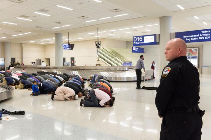 Letalski potniki islamske veroizpovedi molijo na letališču, kjer so ostali ujeti, potem ko je predsednik ZDA podpisal odločbo o prepovedi vstopa državljanov nekaterih držav z Bližnjega vzhoda v Združene države Amerike, januar 2017. | Foto: Reuters