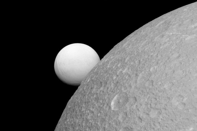Saturnovi luni Enkelad (zadaj) in Diona (spredaj). | Foto: Reuters