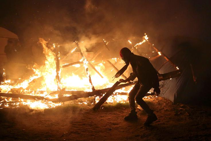 Med požiganjem se je ena oseba lažje poškodovala. | Foto: Reuters