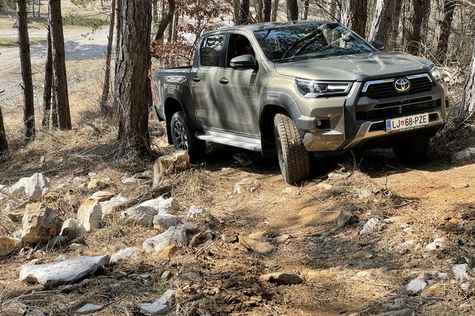 Toyota hilux | Poltovornjak je resda dolg več kot pet metrov in ima tudi več kot tri metre medosne razdalje, toda zanesljiv pogon in oddaljenost od tal (21−33 centimetrov) ga naredita zelo konkurenčnega tudi izven urejenih cest. | Foto Gregor Pavšič