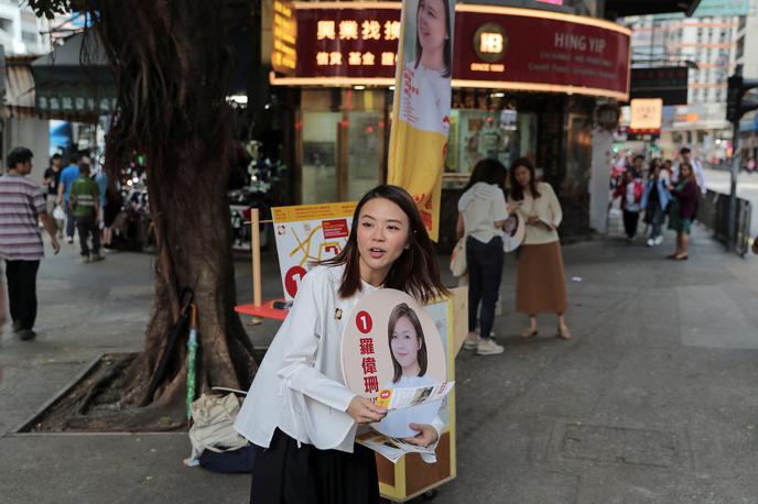 HongKong | Prebivalka Hongkonga z volilnim plakatom ene od kandidatk. | Foto Reuters