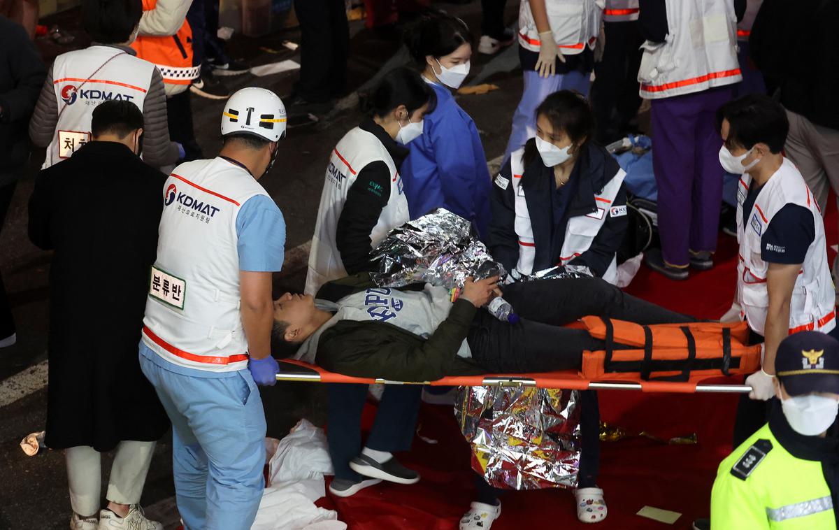 Stampedo | Na posnetkih z dogodka je videti več kot deset negibnih ljudi, ki ležijo na tleh, reševalci pa jim skušajo pomagati. | Foto Reuters