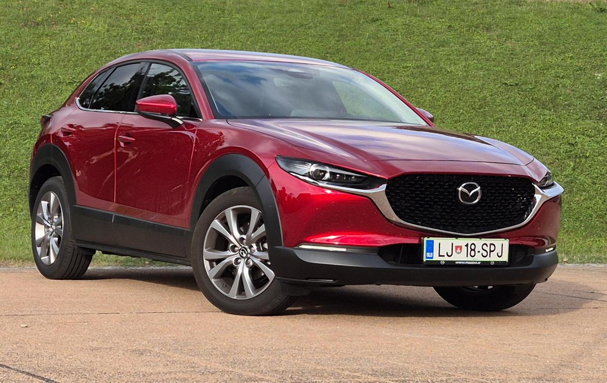 Mazda CX-30 | Rdeča barva je še vedno unikatna, vpadljivo izstopa tudi velika maska, ki povezana s kromom sega do tankih žarometov. Preklop med dolgo in zasenčeno LED svetlobo kajpada deluje avtomatsko.  | Foto Aleš Črnivec