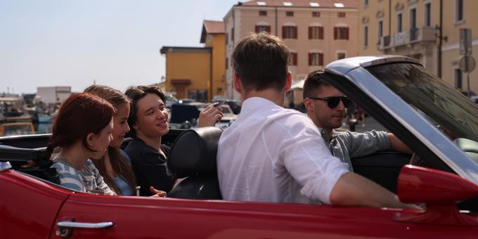Glavni igralci se drenjajo na zadnjem sedežu, ko dobijo prevoz v Piran s pevcem skupine LPS, ta v filmu nadomesti lik Jana Plestenjaka. | Foto: Željko Stevanić @bladeprodukcija