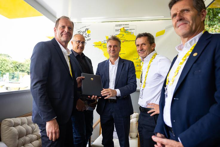 Premier Robert Golob je pismo o nameri za organizacijo starta Toura v Sloveniji za leto 2029 predal direktorju Prudhommu pred startom zadnje etape letošnje dirke.  | Foto: Vlada Republike Slovenije