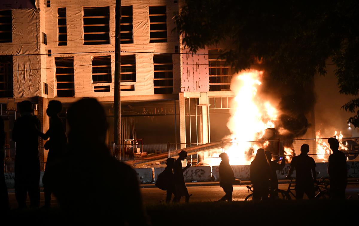 Policija v Minneapolisu | Protestniki v Minneapolisu so vdrli v policijsko postajo, iz katere so policisti pobegnili, in jo zažgali. Razgrajači so zažigali tudi druge zgradbe in ropali trgovine, iz katerih so odnašali vse od cigaret do plenic in hrane. | Foto Reuters