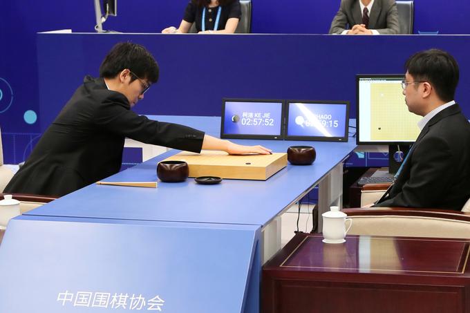 Ke Jie proti AlphaGo. Igralne figurice umetne inteligence je premikal človeški pomočnik.  | Foto: Reuters