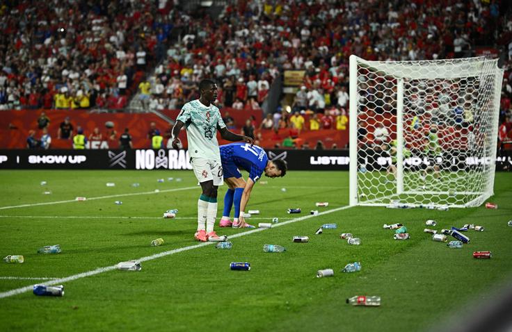 Ko je sodnik razveljavil izenačenje Hrvaške na 2:2, so besni hrvaški navijači zasuli zelenico s steklenicami, pločevinkami in kozarci. | Foto: Reuters