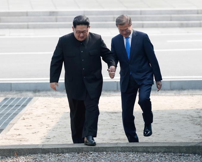 Kim Moonu pomaga prestopiti mejno črto. | Foto: Reuters