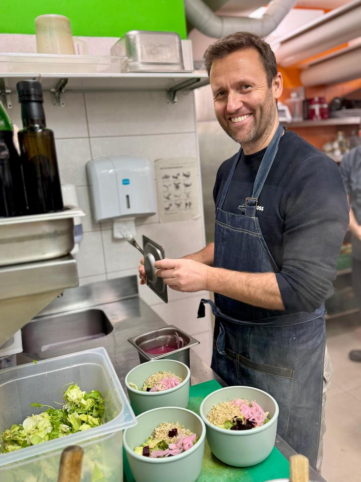 Dr. Sebastjan Perko se je med prvimi udeležil zdrave kuharske delavnice, ki jih v MAHA Bistro vodi njihov glavni kuhar Erik Božič. Zasnovane so kot praktična podpora spremembam prehrane, o katerih se v MAHA z bolniki pogovarjajo že na prvem pregledu. Namenjene so posameznikom ali zelo majhnim skupinam, saj je cilj, da se zdrava prehrana dejansko prenese v vsakdanje življenje. Na delavnicah udeleženci spoznajo konkretne postopke priprave hrane, ki omogočajo boljši vnos hranil, manj industrijskih dodatkov in več zavedanja o tem, kaj telo res potrebuje. Zdrava hrana v MAHA ni dieta ali odrekanje, temveč dolgoročna osnova za energijo, boljše počutje in podaljševanje dobe zdravja. | Foto: arhiv ponudnika