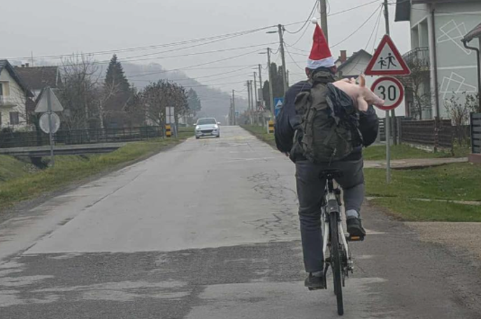 Prašiček | Moški na kolesu je videti praznično razpoložen, saj nosi božično kapo. | Foto FB/Uživo sa slavonskih prometnica
