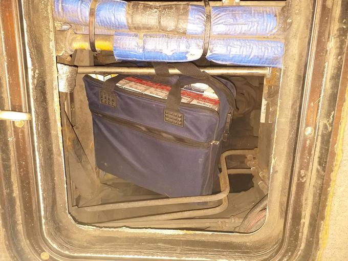 Uslužbenci Fursa so v motornem prostoru vozila odkrili dve potovalki, v kateri je bilo 3.400 kosov cigaret in dva paketa z 2,1 kilograma konoplje. | Foto: policija