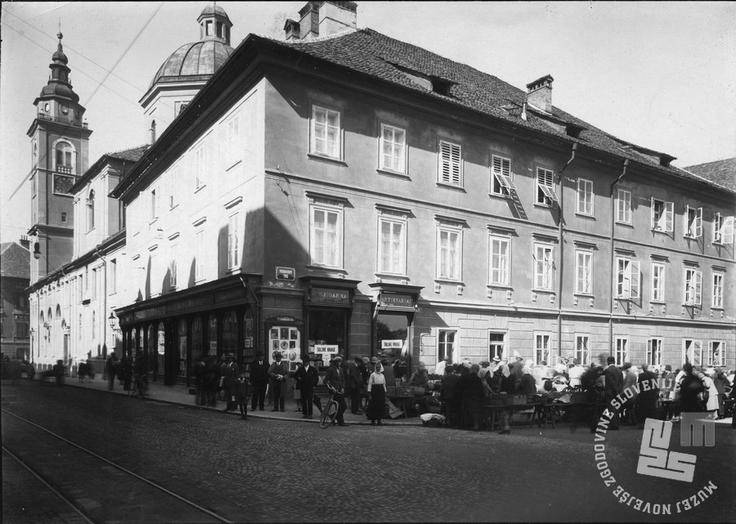 Vodnikov trg Del tržnice na Vodnikovem trgu med obema vojnama, levo je izložba Jugoslovanske knjigarne, na vogalu oglasna vitrina ateljejskega fotografa Frana Grabjeca. V pritličju vogalne hiše, kjer je nekoč bila knjigarna, je danes trgovina s turističnim kičem in spominki. | Foto: neznan, arhiv MNZS