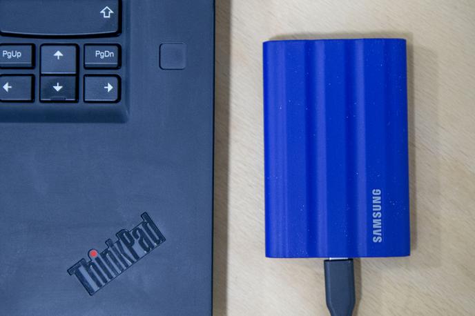 Samsung Portable SSD T7 | Prenosni zunanji disk Samsung Portable SSD T7 Shield – primerjava velikosti s prenosnim računalnikom | Foto Ana Kovač