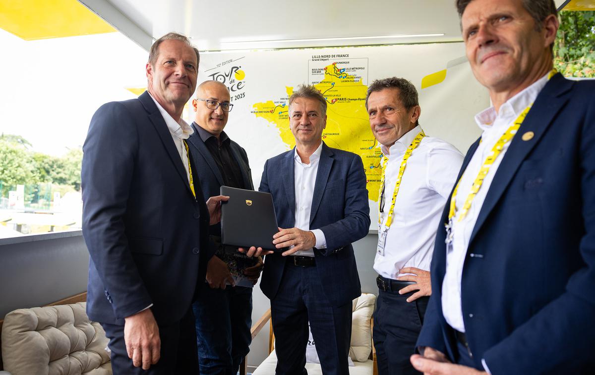 Tour de France Robert Golob | Robert Golob je pred štartom zadnje etape dirke v kraju Mantes-la-Ville direktorju dirke Christianu Prudhommu predal pismo o nameri za organizacijo izvedbe dogodka veliki start Dirke po Franciji v Republiki Sloveniji za leto 2029. | Foto Vlada Republike Slovenije