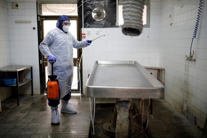 Dezinfekcija prostora, v katerem v izraelskem Tel Avivu pripravljajo trupla žrtev koronavirusa na pokop. | Foto: Reuters