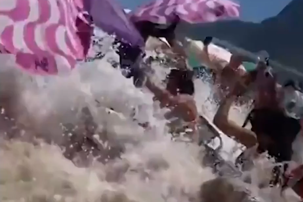Trenutek, ko tri metre visok val trešči na plažo, polno turistov #video
