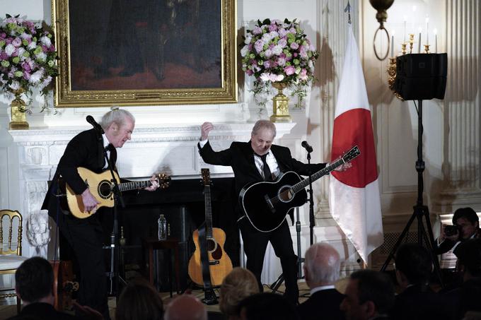Slavnostno prireditev je s svojim glasbenim vložkom popestril tudi glasbenik in umetnik Paul Simon (desno). Zapel je pesmi Graceland in Slip Slidin’ Away, veljal naj bi za ljubljenca prve dame ZDA. | Foto: Profimedia