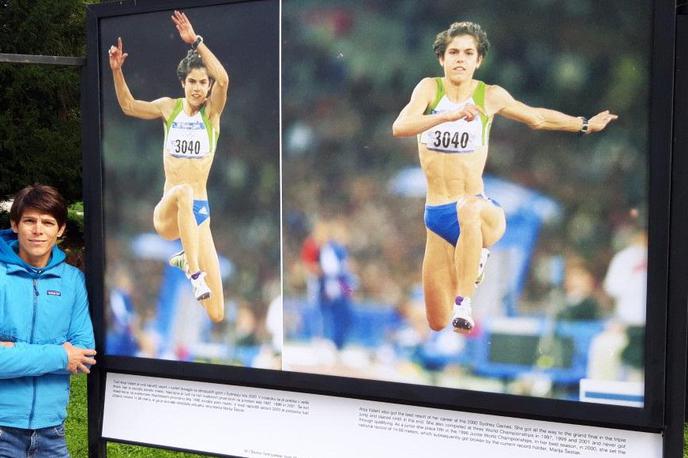 Anja Valant | Anja Valant ob svoji fotografiji z olimpijskih iger v Sydneyju na fotografski razstavi ob 100-letnici slovenske atletike v ljubljanskem parku Tivoli. | Foto osebni arhiv