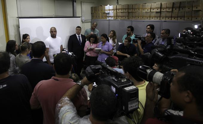 Obkrožen z novinarji po zaslišanju na policijski postaji leta 2011 | Foto: Reuters