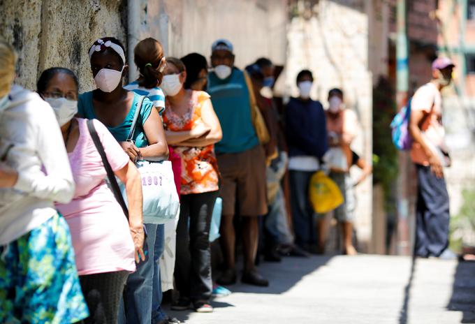 Ljudje v Caracasu med epidemijo novega koronavirusa čakajo na donacijo hrane.  | Foto: Reuters