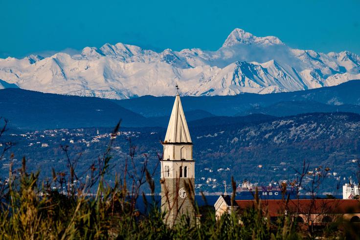 Zvonik cerkve sv. Mavra s Triglavom v ozadju | Foto: Shutterstock