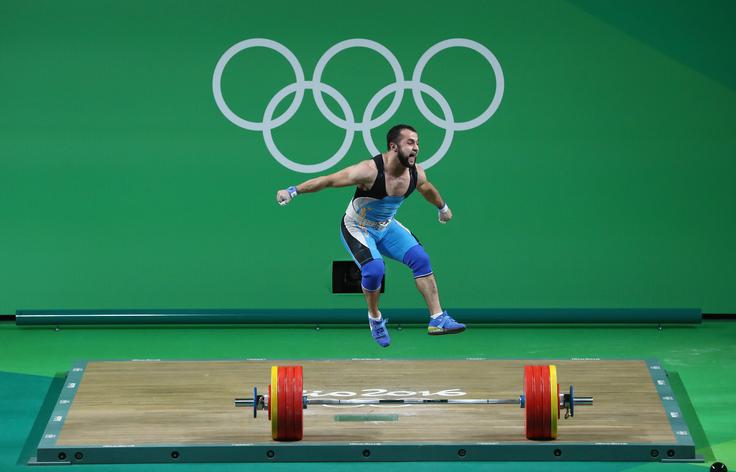 Nijat Rahimov iz Kazahstana je v dvigovanju uteži (do 77 kg) osvojil zlato medaljo. Za veliko zmago je dvignil kar 379 kilogramov in s tem postavil nov svetovni rekord. Da mu je uspel veliki met, pove njegova reakcija po velikem dosežku. | Foto: Getty Images