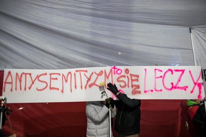 Med sprejemanjem zakona o holokavstu so se na ulice Varšave podali tako njegovi podporniki kot nasprotniki. Transparent s napisom "Antisemitizem je ozdravljiv" pripada drugim. | Foto: Reuters