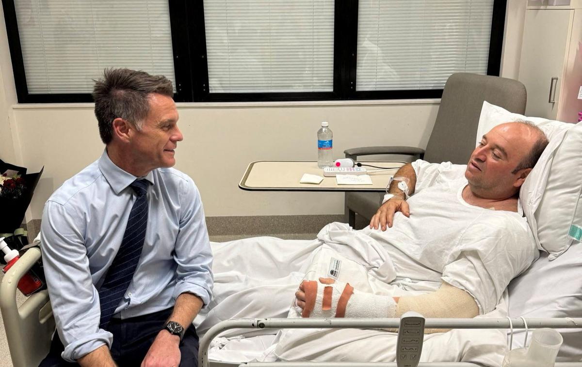 Ahmed Al Ahmed, Chris Minns | Premier avstralske zvezne države Novi Južni Wales Chris Minns je objavil fotografijo srečanja in zapisal: "Ahmed je junak dneva. Sinoči je s svojim neverjetnim pogumom nedvomno rešil nešteto življenj, ko je razorožil terorista, pri čemer je sam ogromno tvegal. V čast mi je bilo preživeti čas z njim." | Foto Reuters