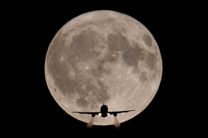 Potniško letalo se približuje britanskemu letališču Heathrow v bližini Londona; v ozadju polna luna, oktober 2017. | Foto: Reuters