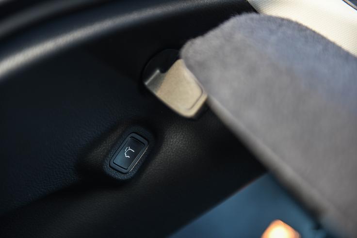 Tipka za elektronsko zapiranje prtljažnih vrat je skrita na levi strani, znotraj prtljažnika pod polico. Ne le, da je njena pozicija skrita, če nisi previden in se hitro umakneš, te spuščajoča prtljažna vrata hitro udarijo po betici. | Foto: Gašper Pirman