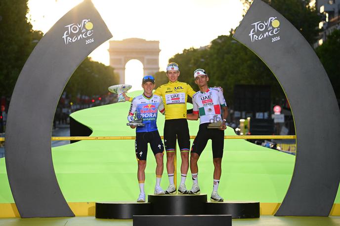Tadej Pogačar, TdF 2026 | Tadeju Pogačarju sta tokrat družbo na odru za zmagovalce delala Remco Evenepoel in Isaac Del Toro. | Foto Reuters