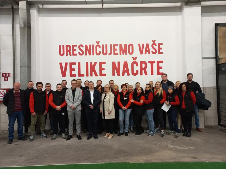 Kolektiv Cash & Cary Ljubljana z vodstvom Mercatorjeve Veleprodaje – slogan nad njimi pove vse. | Foto: Mercator