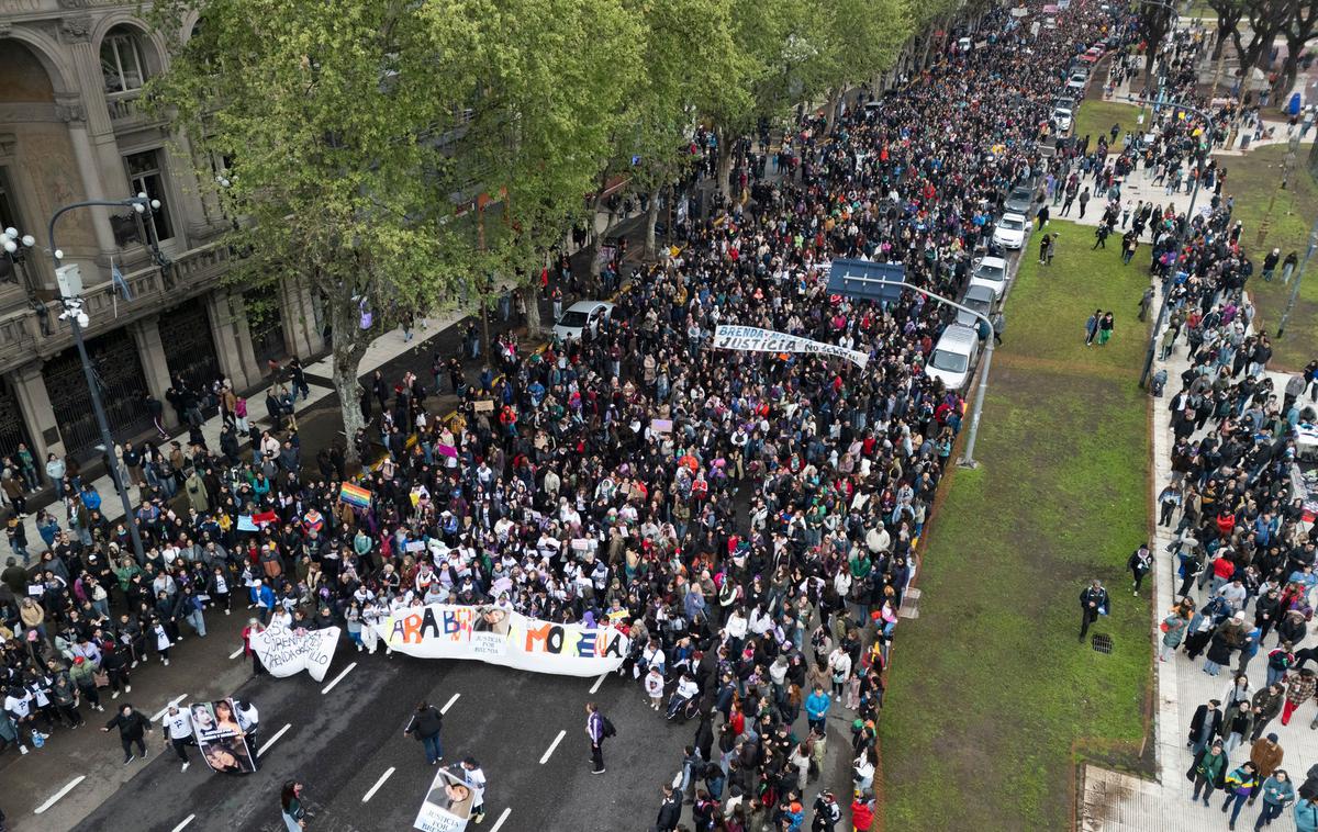 Argentina, protest | Med sobotnim protestnim pohodom so sorodniki žrtev, obkroženi s podporniki, do poslopja argentinskega parlamenta nosili transparent z imeni žrtev in plakate z njihovimi podobami. | Foto Profimedia