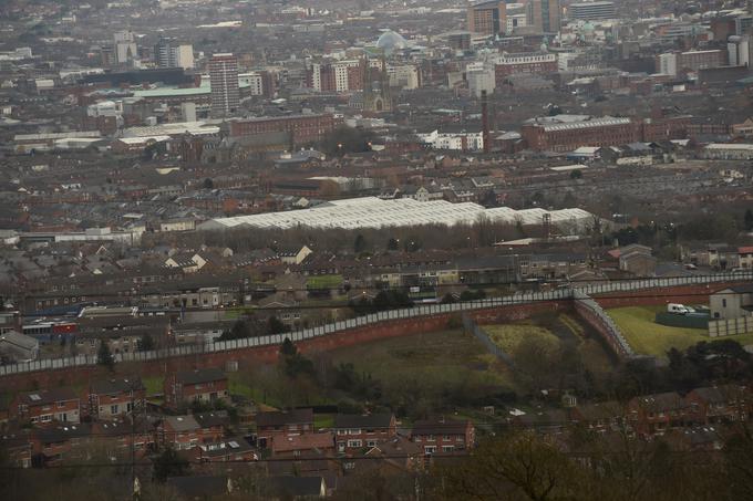 Ena od posledic severnoirskega konflikta je tudi segregacija. Na fotografiji je viden zid, ki v Belfastu ločuje protestantsko in katoliško skupnost. | Foto: Reuters